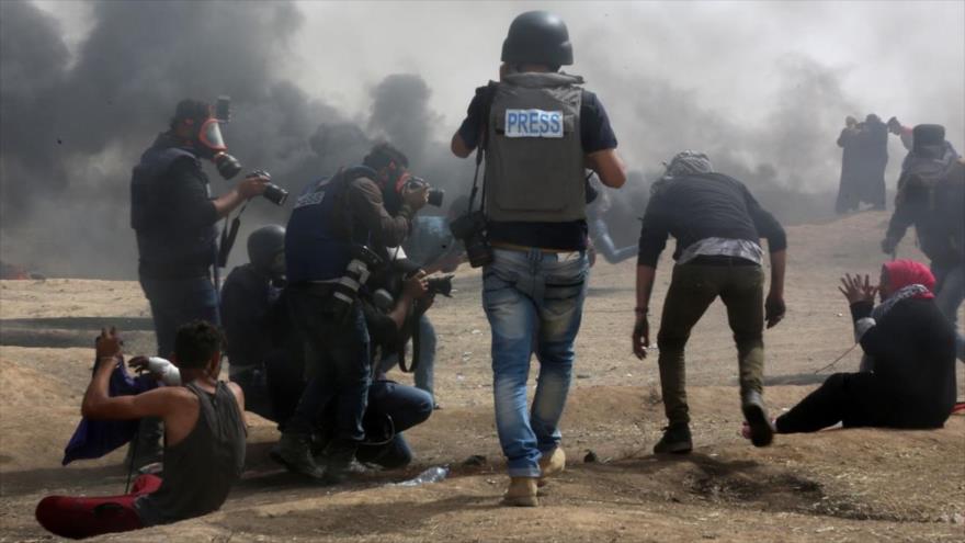 Periodistas cubren la violencia israelí en una protesta en la frontera de la Franja de Gaza, 20 de abril de 2018. 