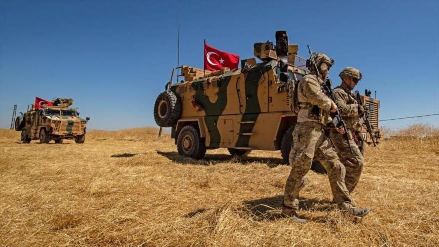 Soldados estadounidenses junto a un vehículo militar turco durante una patrulla conjunta en Siria. (Foto: AFP)