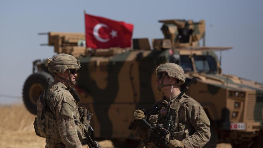 Soldados estadounidenses y un blindado turco durante una patrulla conjunta cerca de la ciudad siria de Tal Abyad, 8 de septiembre de 2019. (Foto: AP)