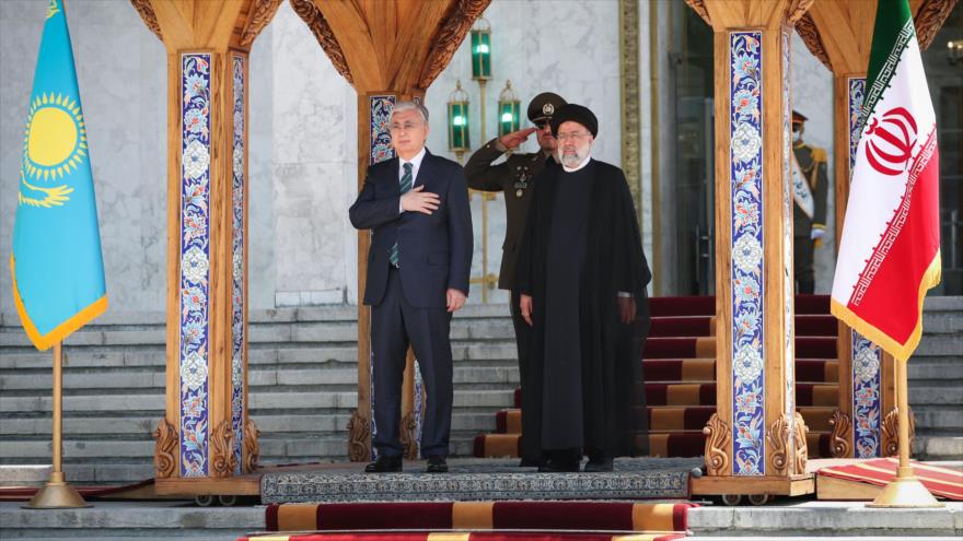 El presidente de Kazajistán (izda.) es recibido por su par iraní, Seyed Ebrahim Raisi, en el Palacio de Saad Abad en Teherán, capital persa, 19 de junio de 2022.
