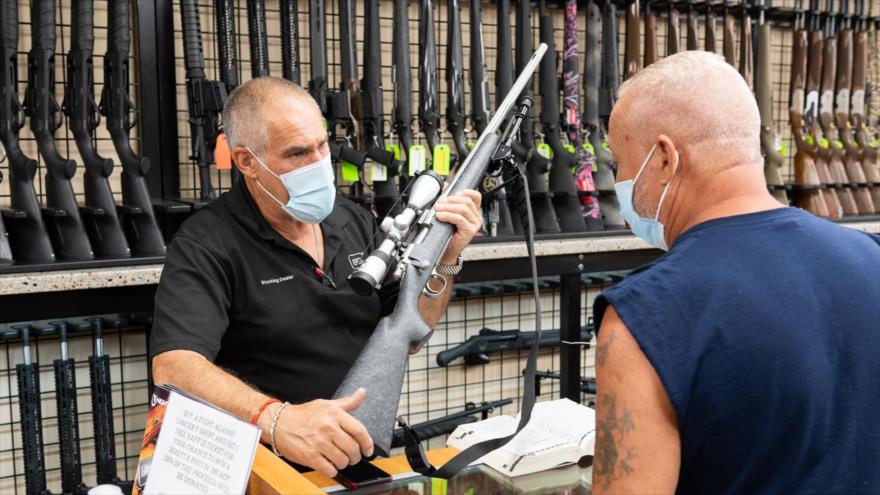Un vendedor de armas muestra un rifle a un cliente en una tienda de Nueva York.