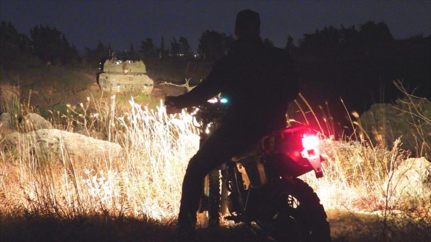 Un motociclista de Hezbolá impide avance de tanques israelíes Merkava en la frontera entre los territorios ocupados y El Líbano.