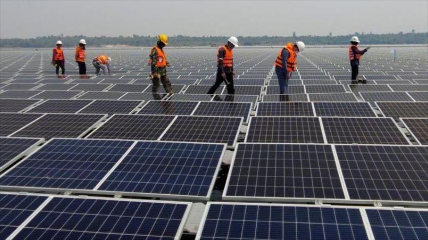 Un grupo de trabajadores supervisa una instalación de paneles solares sobre superficie acuática en, Tailandia, abril de 2021.