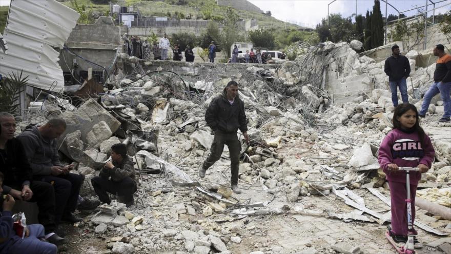 Los palestinos observan una casa familiar destruida por las autoridades israelíes, en Silwan, la ocupada ciudad de Al-Quds, 17 de abril de 2019.