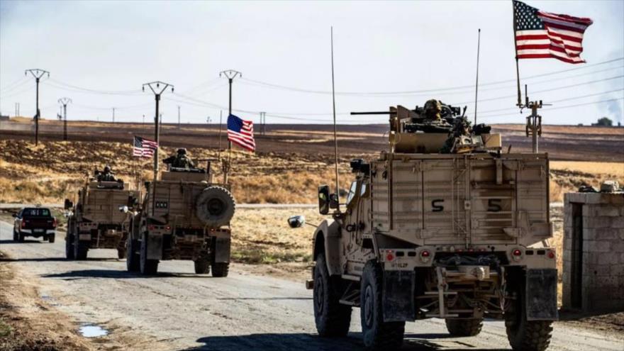 Vehículos blindados estadounidenses pasan por un pozo de petróleo en la provincia nororiental siria de Al-Hasakah. (Foto: AFP)