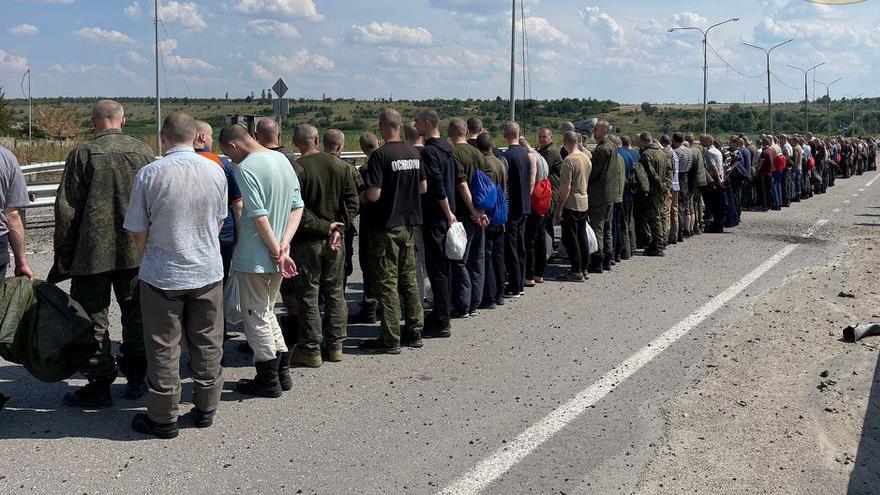 Los prisioneros hacen fila junto a una carretera durante un intercambio de prisioneros, en Zaporíjia, Ucrania. (Foto: Reuters)