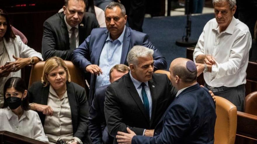Yair Lapid (c) y Naftali Bennet (2.º dcha.) se dan la mano después de que el parlamento israelí se disolviese, 30 de junio de 2022. (Foto: Getty Images)