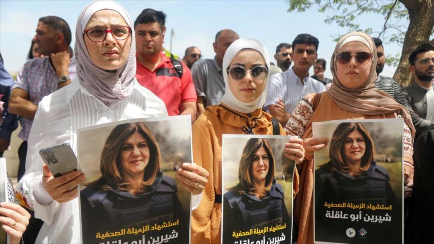 Mujeres palestinas sostienen imágenes de la periodista de Al Jazeera, Shireen Abu Akleh en su funeral en Yenín, Cisjordania, 13 de mayo de 2022. (Foto: AP)