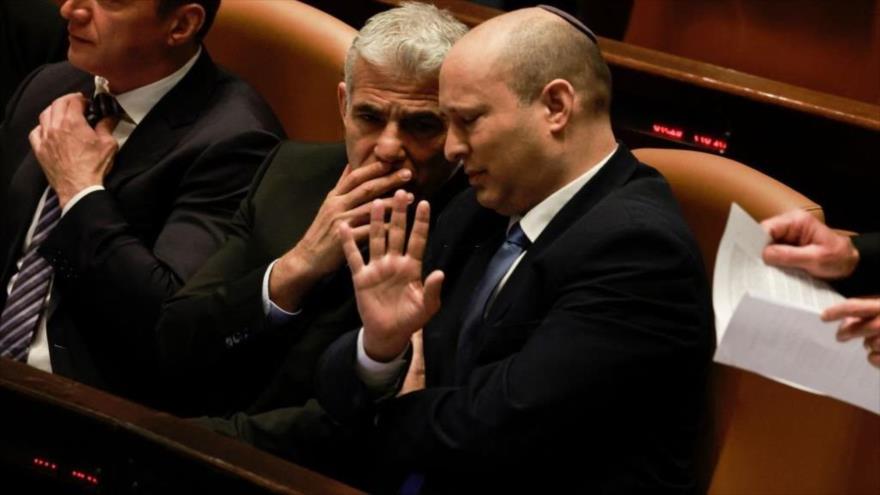 El primer ministro israelí, Yair Lapid, y su predecesor en el poder Naftali Bennett durante una sesión del parlamento, 30 de junio de 2022.
