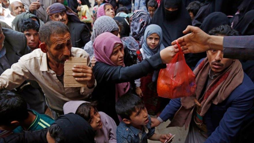 Familias afectadas por guerra y asedio de Riad acuden en masa para recibir almuerzos gratuitos en Saná, 29 de junio de 2021. (Foto: Getty Images)