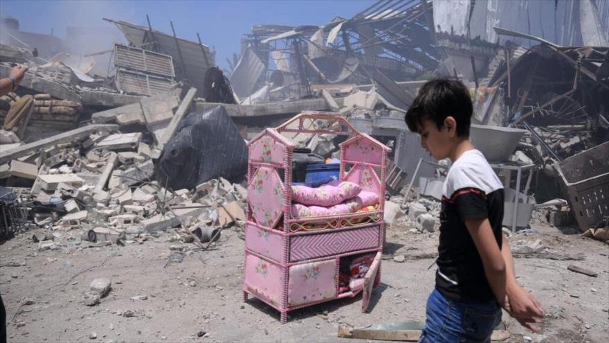 Un niño palestino anda entre las ruinas de su casa en Gaza después de que fuera destruida por un ataque aéreo israelí, 14 de mayo de 2021. (Foto: NYT)
