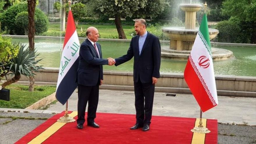 El canciller iraní, Hosein Amir Abdolahian (dcha.), recibe a un homólogo iraquí, Fuad Husein, en Teherán, capital persa, 13 de abril de 2022.