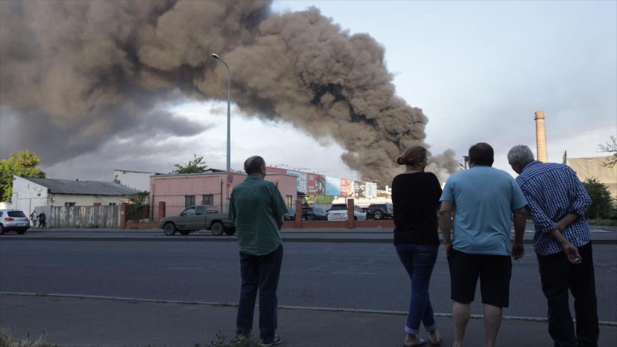 La gente observa nube de humo de incendio en el fondo después de un ataque con misiles en Odesa, Ucrania, 16 de julio de 2022. (Foto: AFP)