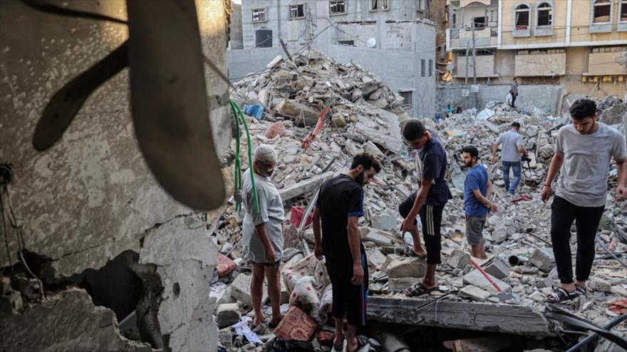 Los palestinos evalúan un edificio residencial colapsado por los ataques aéreos israelíes en Rafah, en el sur de la Franja de Gaza, 7 de agosto de 2022. (Foto: AFP)