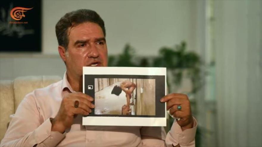 Muhamad Belandian muestra su foto mientras las fuerzas estadounidenses lo desnudaron cuando fue encarcelado en la cárcel de Abu Ghraib, Irak.
