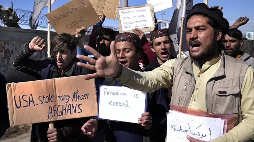 Los manifestantes afganos sostienen pancartas y gritan consignas contra la decisión del presidente de EEUU, Joe Biden, de destinar los fondos afganos a víctimas del 11-S, en Kabul.