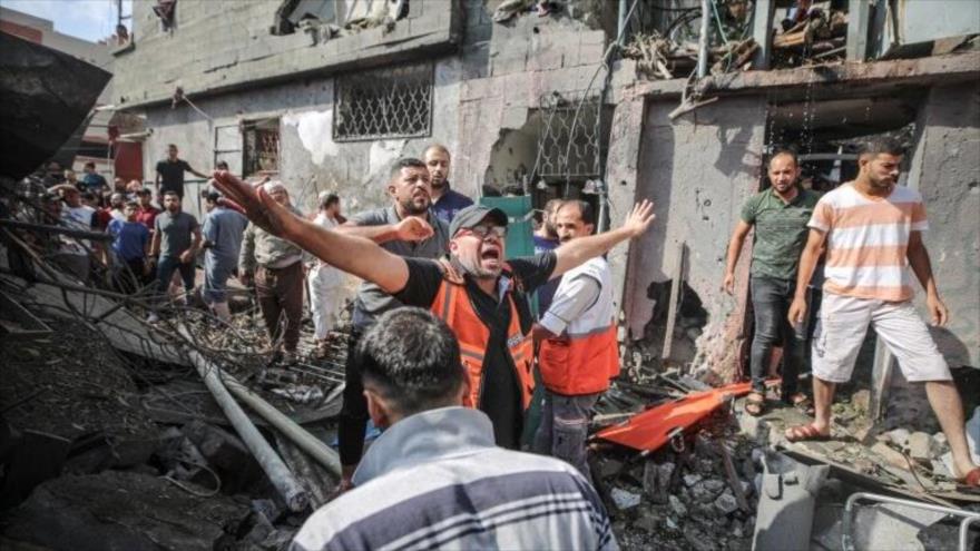 Equipos palestinos y la gente inspeccionan los daños luego de un ataque aéreo israelí en un campo de refugiados, al norte de Gaza, 7 de agosto de 2022.
