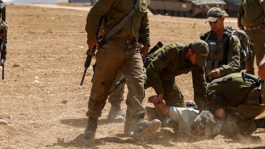Soldados israelíes detienen a un palestino en la Cisjordania ocupada, 22 de junio de 2022. (Foto: AFP)
