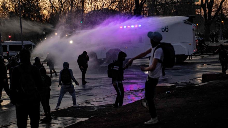 La policía chilena dispersa con chorros de agua a los estudiantes que protestan en Santiago de Chile, 9 de septiembre de 2022. (Foto: AFP)