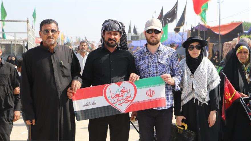 Peregrinos con banderas de Irán e Irak participan en la caminata de Arbaían.
