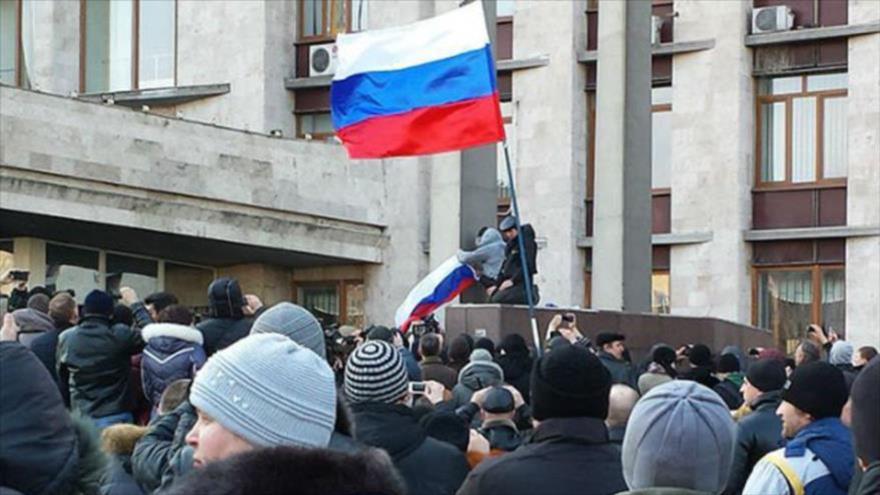 Manifestantes prorrusos cambian la bandera ucraniana con la rusa frente al edificio del Consejo Regional de Donetsk. (Foto: Ostro.org)