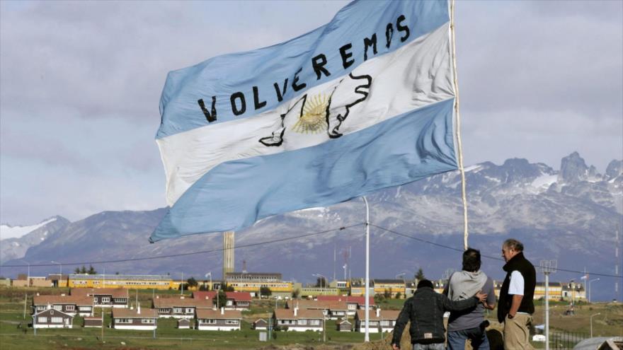 Sostienen una bandera argentina tras una ceremonia para conmemorar el aniversario de la Guerra de Malvinas en Ushuaia, sur de Argentina. (Foto: AFP)