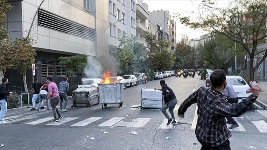 Alborotadores lanzan piedra a los agentes antidisturbios, Irán. 