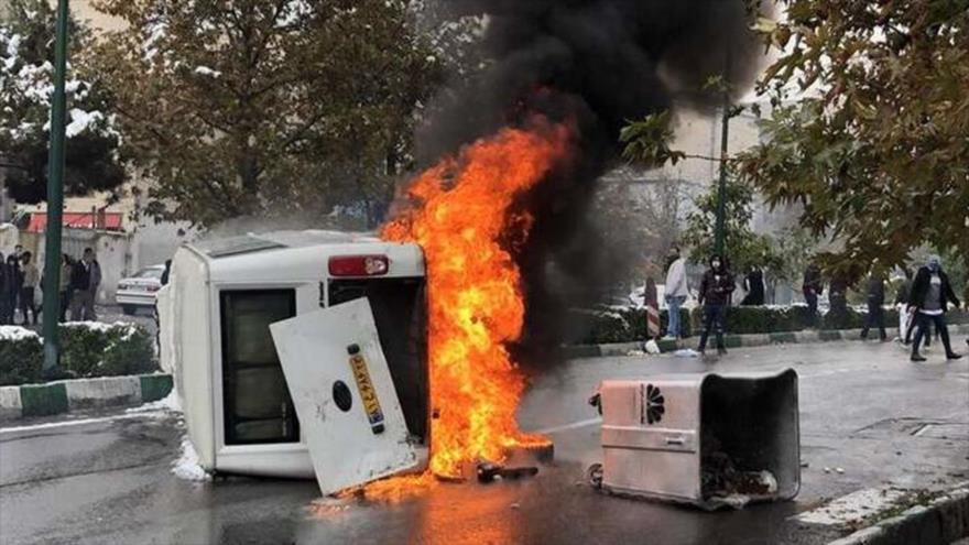 Los alborotadores prendieron fuego a un auto.