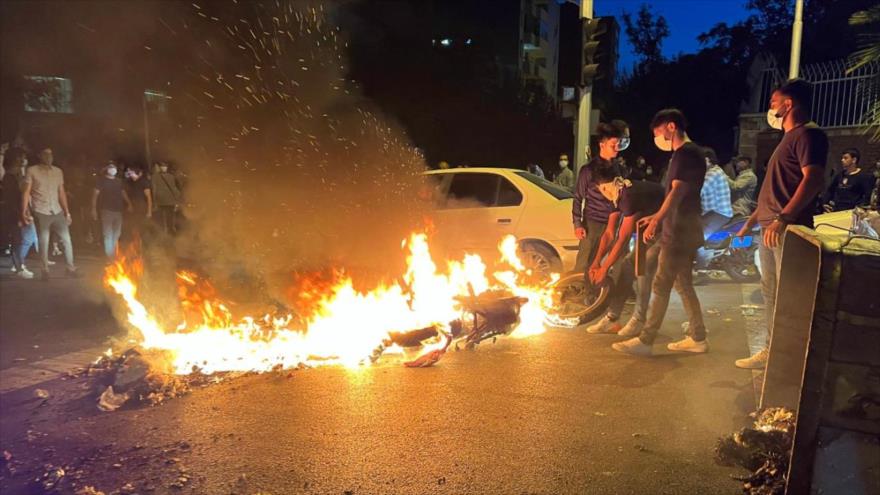 Alborotadores prenden fuego a una motocicleta durante una protesta por la muerte de Mahsa Amini en Teherán, 19 de septiembre de 2022. (Foto: AFP)