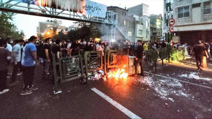 Alborotadores queman un contenedor de basura en Teherán, capital iraní, 21 de septiembre de 2022. (Foto: AFP)