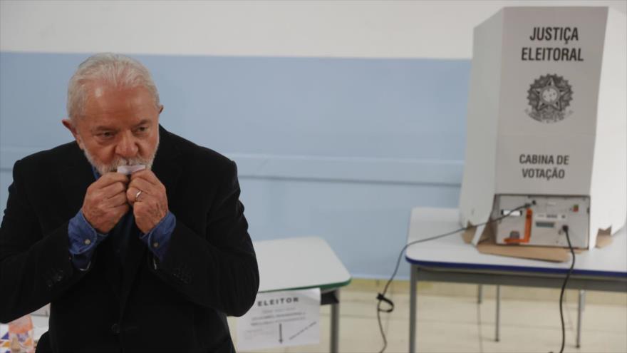 El expresidente brasileño Lula da Silva besa su comprobante de votación en un colegio electoral, 2 de octubre de 2022.