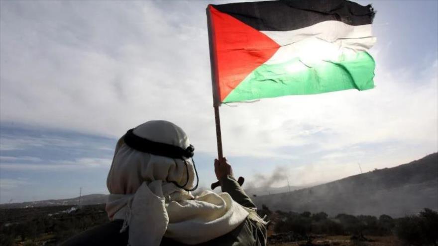 Un palestino ondea la bandera palestina durante una protesta en Cisjordania, 10 de diciembre de 2021.