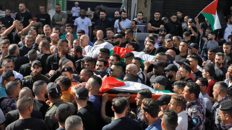 Llevan cuerpos de dos palestinos muertos durante su funeral en el campamento de Askar, cerca de Nablus, 28 de octubre de 2022. (Foto: AFP)