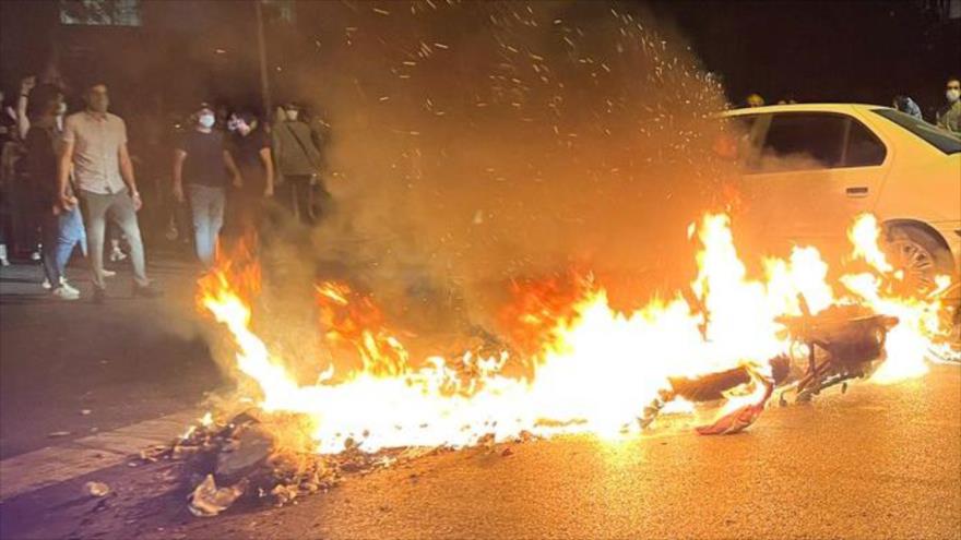 Motocicleta de la policía se quema durante disturbios en Teherán, capital de Irán, 19 de septiembre de 2022.