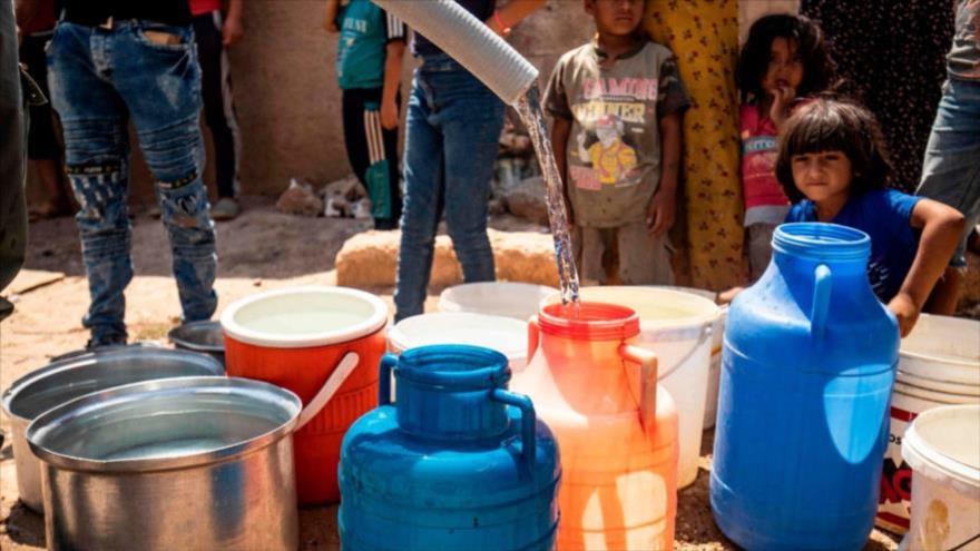 Sirios llenan agua de cisternas proporcionadas por organizaciones humanitarias durante un corte de agua en Al-Hasaka, 22 de agosto de 2020. (Foto: AFP)