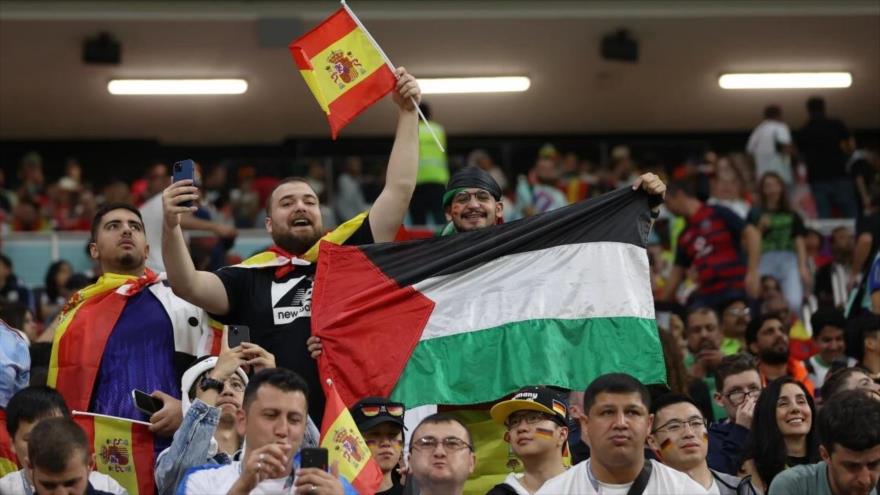 Los seguidores de la selección española sostienen una bandera palestina en la Copa Mundial de Catar 2022.