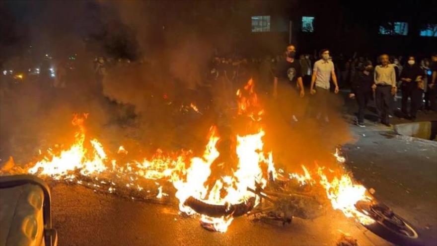 Alborotadores bloquean una calle quemando motos y contenedores de basura, Teherán, 30 de septiembre de 2022. 
