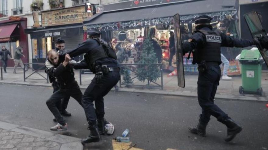 Policía gala choca con un miembro de la comunidad kurda tras la muerte de tres kurdos en un tiroteo en París, 23 de diciembre de 2022. (Foto: AP)