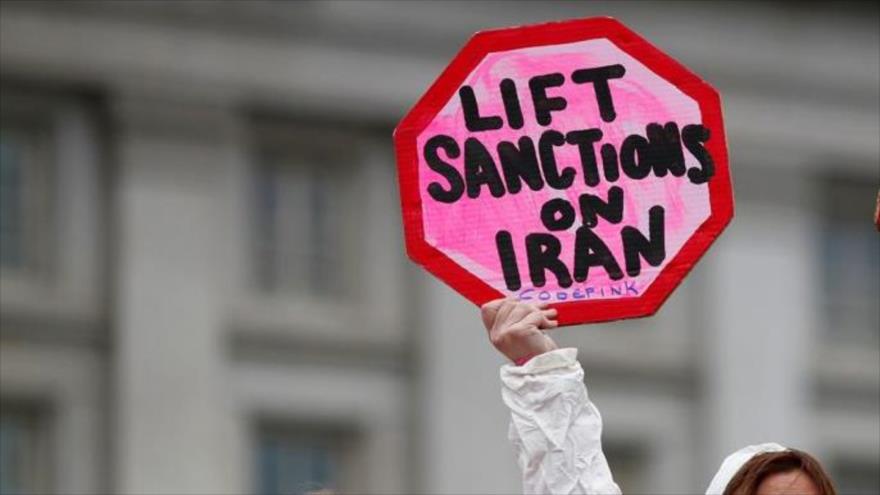 Una activista sostiene una pancarta para exigir el levantamiento de las sanciones contra Irán durante una protesta frente al Departamento del Tesoro de EE.UU.