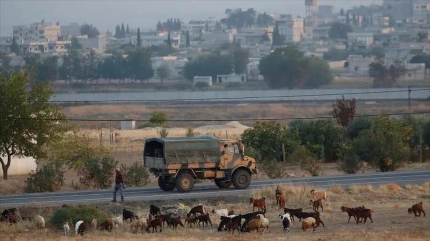 Un camión militar turco circula por la frontera turco-siria, con la ciudad siria de Kobani al fondo, 31 de octubre de 2019. (Foto: Reuters)