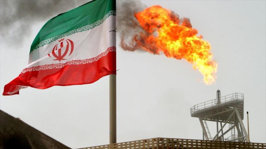 Se ve una llamarada de gas en una plataforma, junto a una bandera iraní en el Golfo Pérsico, 25 de julio de 2005. (Foto: Reuters)