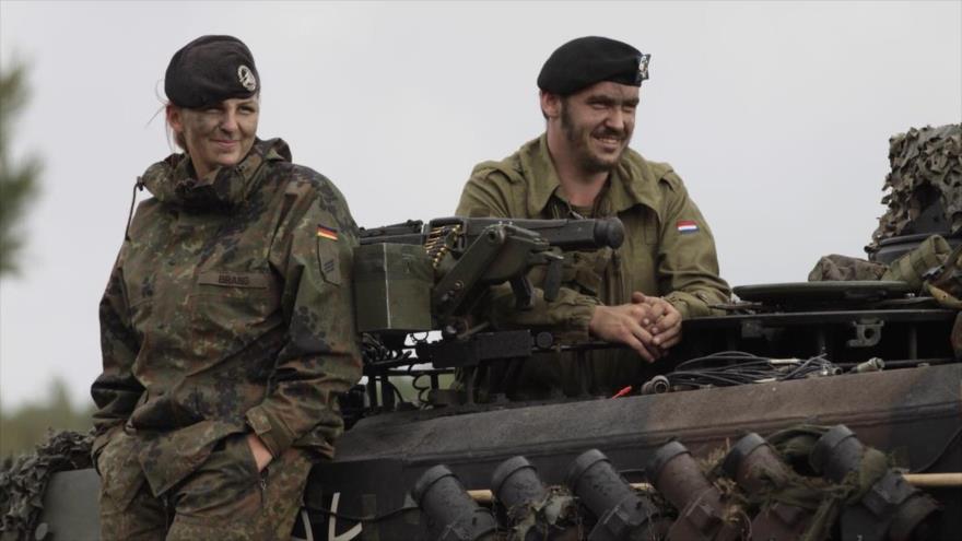 Dos soldados del batallón mixto 414 de tanques alemán y holandés en la parte superior de un tanque Leopard II A6.