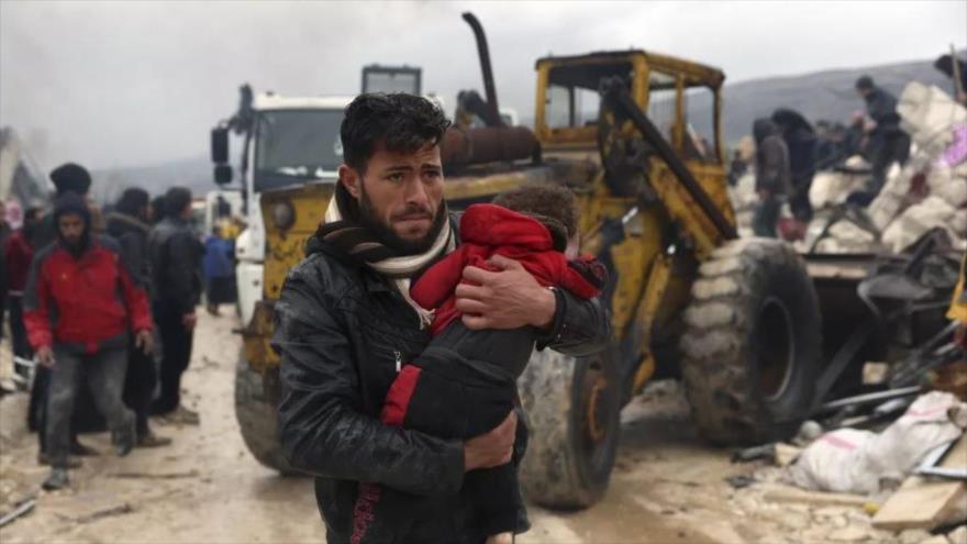 Un hombre carga el cuerpo de un niño que murió a causa del sismo en la localidad de Besnia, en la provincia de Idlib, en Siria, 6 de febrero de 2023. (Foto: AP)