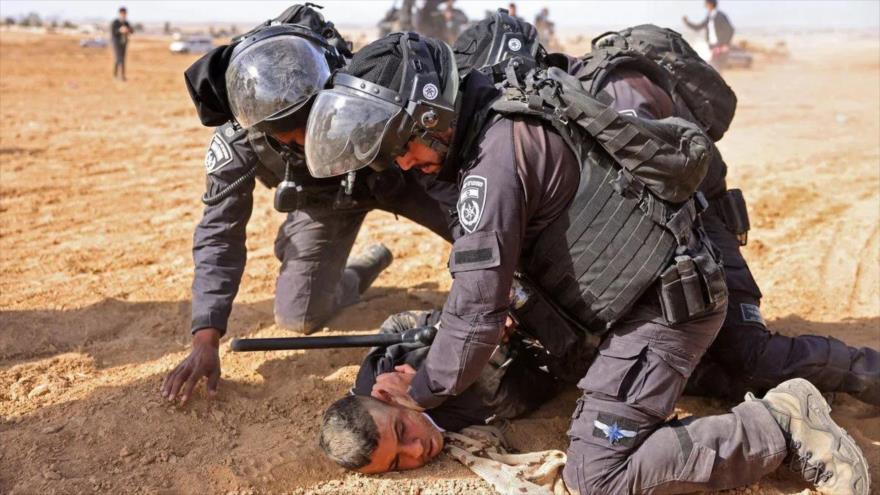 Fuerzas israelíes arrestan a un palestino en la aldea de Al-Atrash en el desierto de Al-Naqb (Néguev), 12 de enero de 2022. (Foto: AFP)