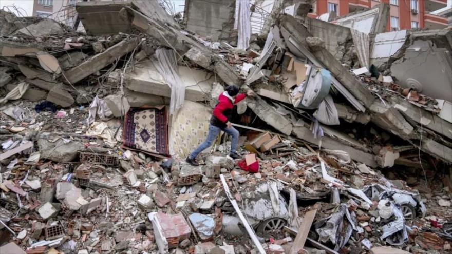 Un hombre busca sobrevivientes entre los escombros de un edificio n Adana, Turquía, 6 de febrero de 2023. (Foto: AP)