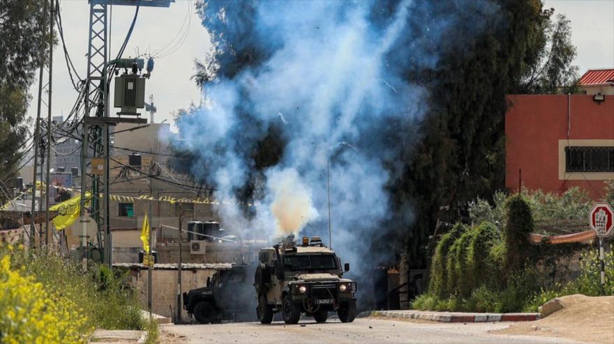 Un vehículo militar israelí, disparando gas lacrimógeno cerca del campo de refugiados de Yenín en la Cisjordania ocupada, 9 de abril de 2022. (Foto: AFP)