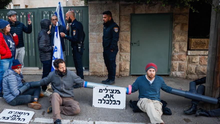 Un grupo de manifestantes israelíes se atan a la casa del ministro de Economía, Nir Barkat, Palestina ocupada, 22 de febrero de 2023.
