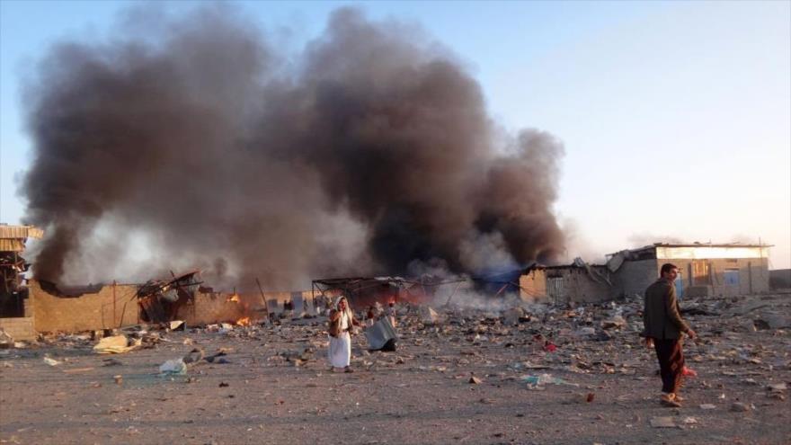 El humo se eleva mientras los yemeníes inspeccionan los daños en el lugar de los ataques aéreos en Saada, Yemen, 6 de enero de 2018. (Foto: AFP)