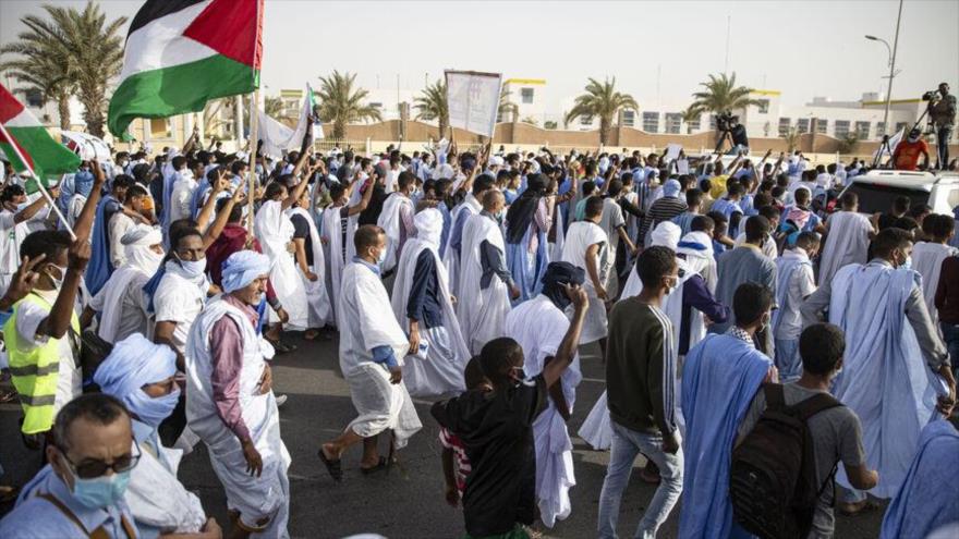 Los manifestantes llevan la bandera palestina durante una marcha en apoyo del pueblo palestino en Nuakchot, capital de Mauritania, 19 de mayo de 2021. 
