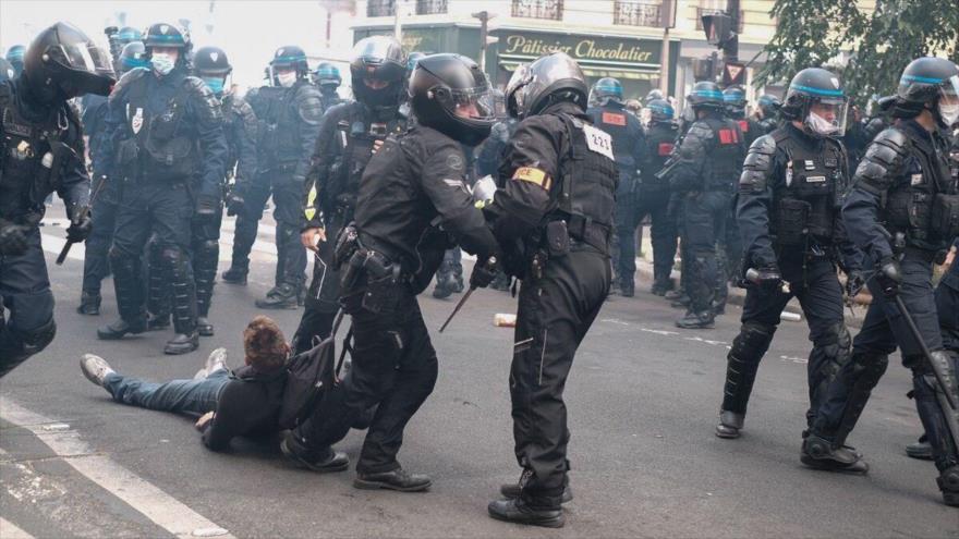 Agentes de policía franceses detienen a un manifestante durante una protesta antigubernamental.